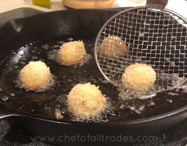 frying mashed potato bites in a skillet