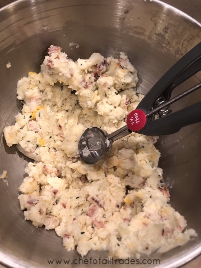 Mashed potato ingredients in a mixing bowl with scoop