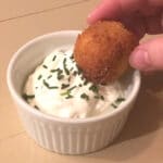 Loaded Mashed Potato Bite being dipped in sour cream
