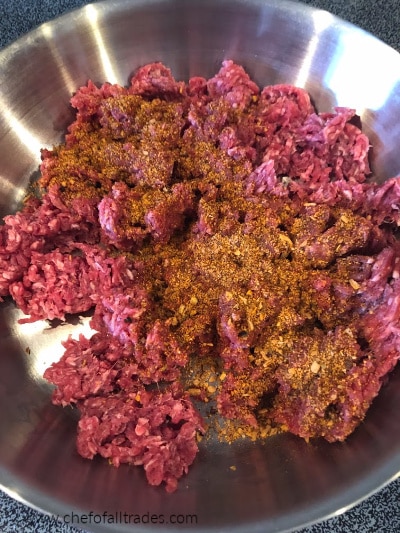 seasoning added to meat in a pan