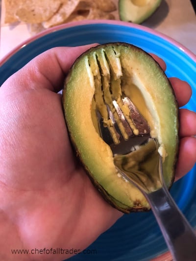 avocado being mashed in hand