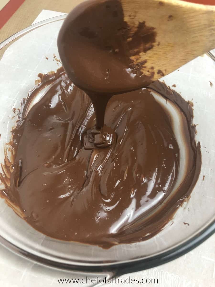 Melted Chocolate in a glass bowl with a wooden spoon