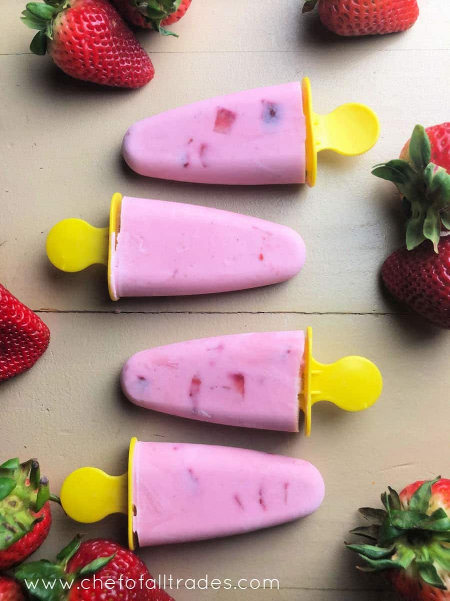 Strawberry Yogurt Pops on table surrounded by strawberries
