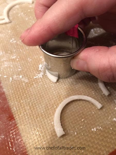 cutting lash shapes out of gum paste with a round cookie cutter.