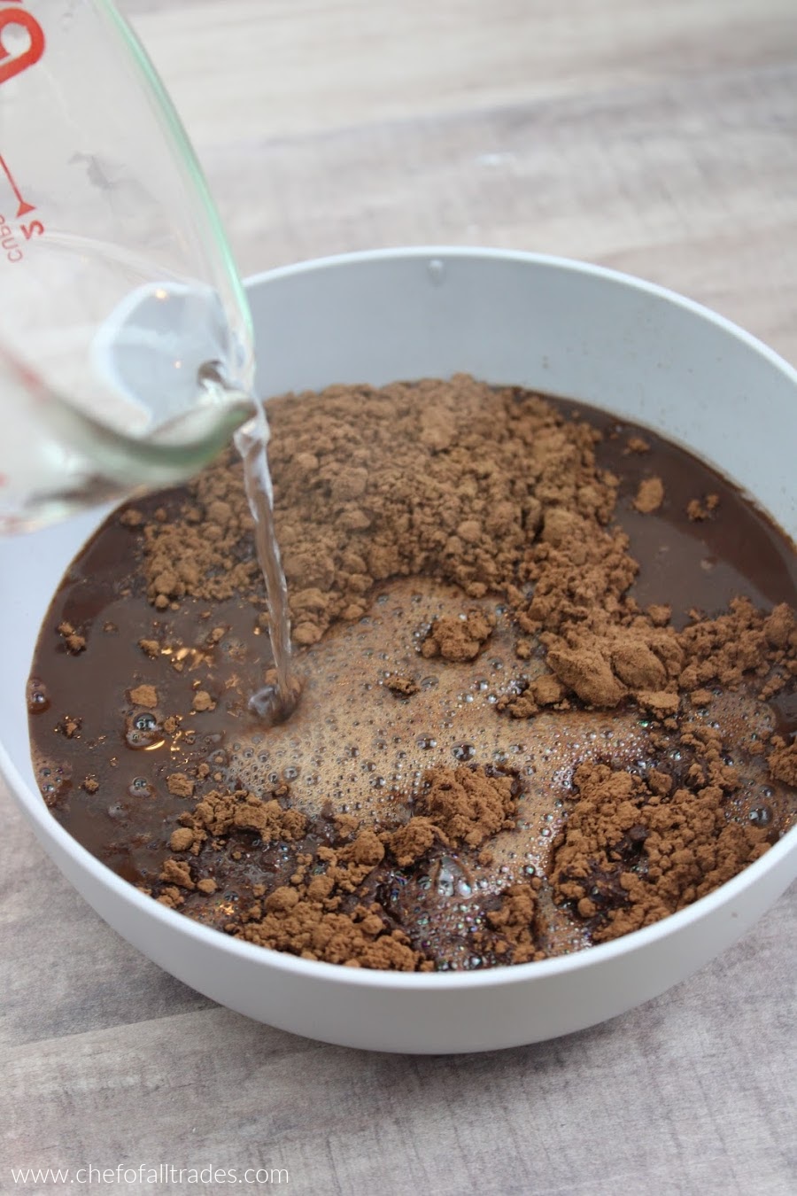 adding the water and cocoa together in a gray bowl