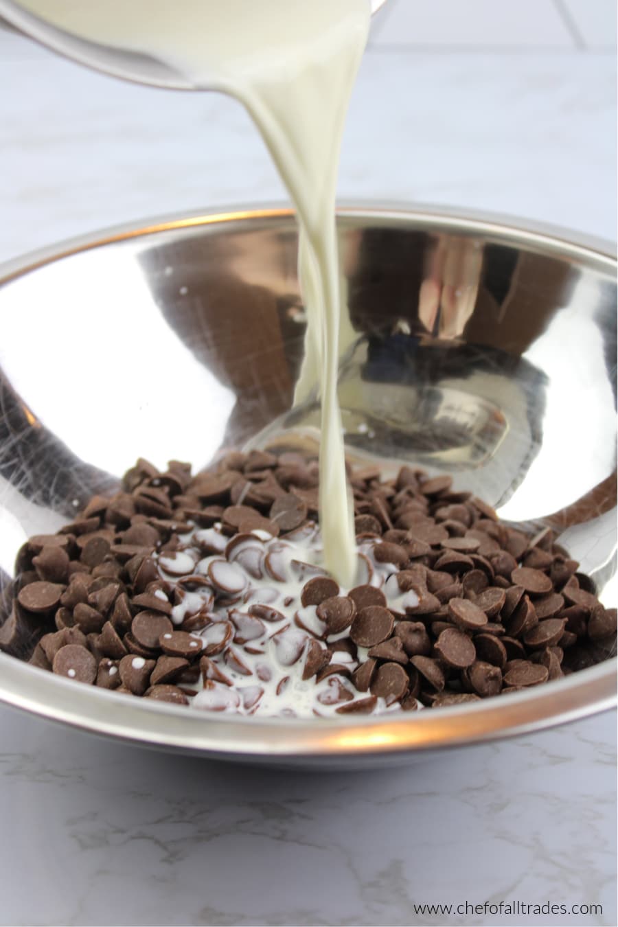 pouring heavy cream into chocolate chips to make ganache