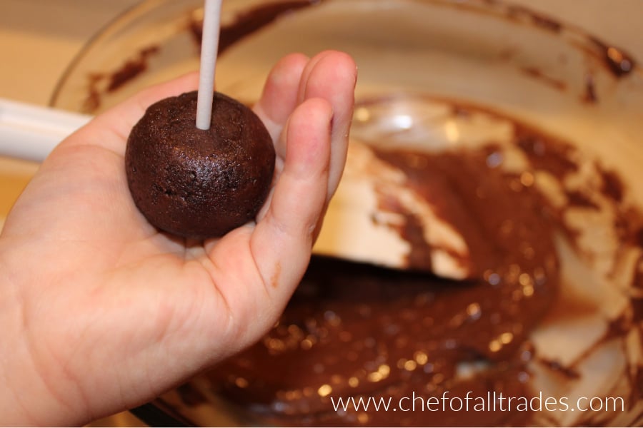 using stick to puts holes in the base of the cake pop balls