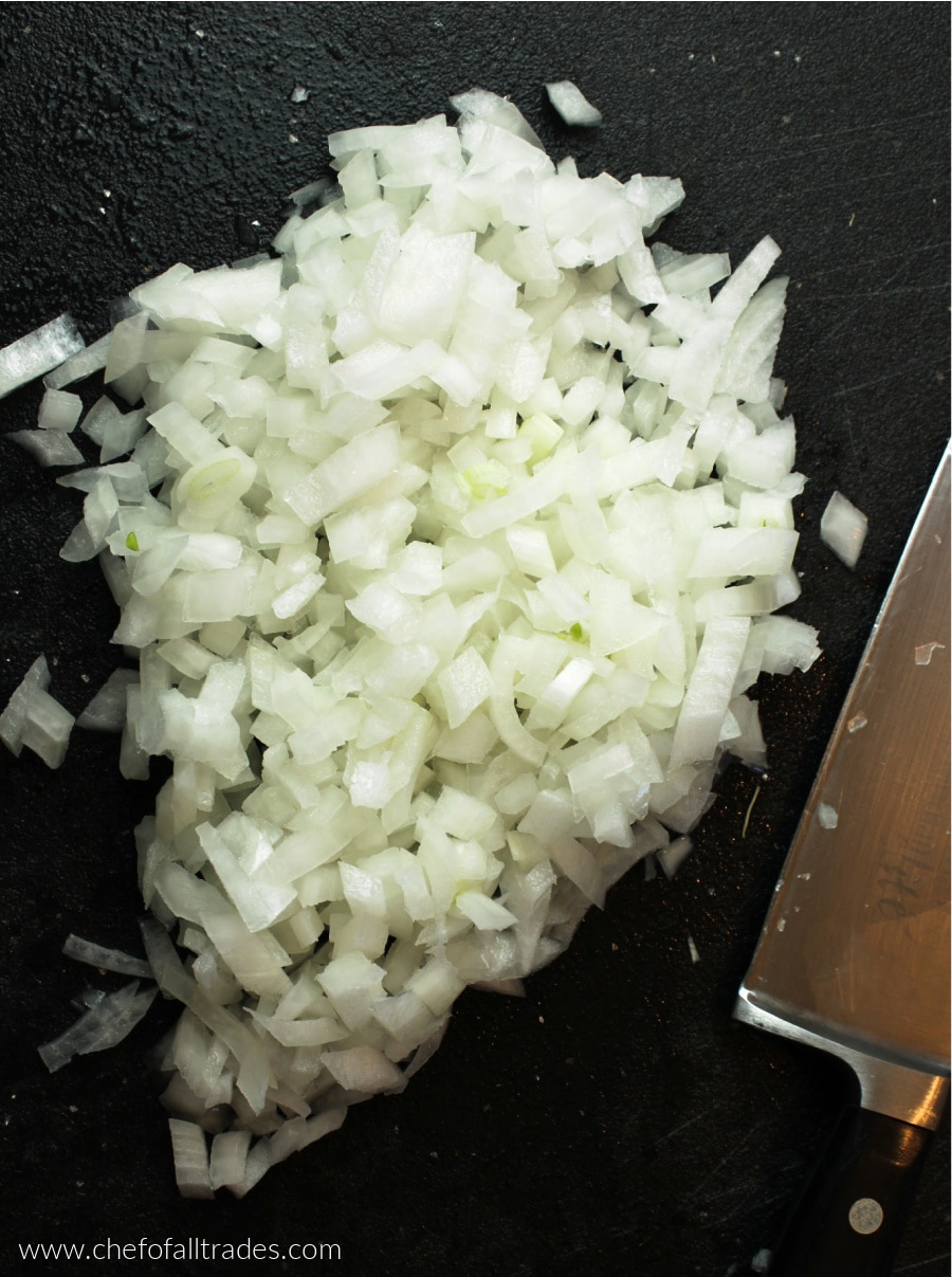 diced white onions of a black cutting board