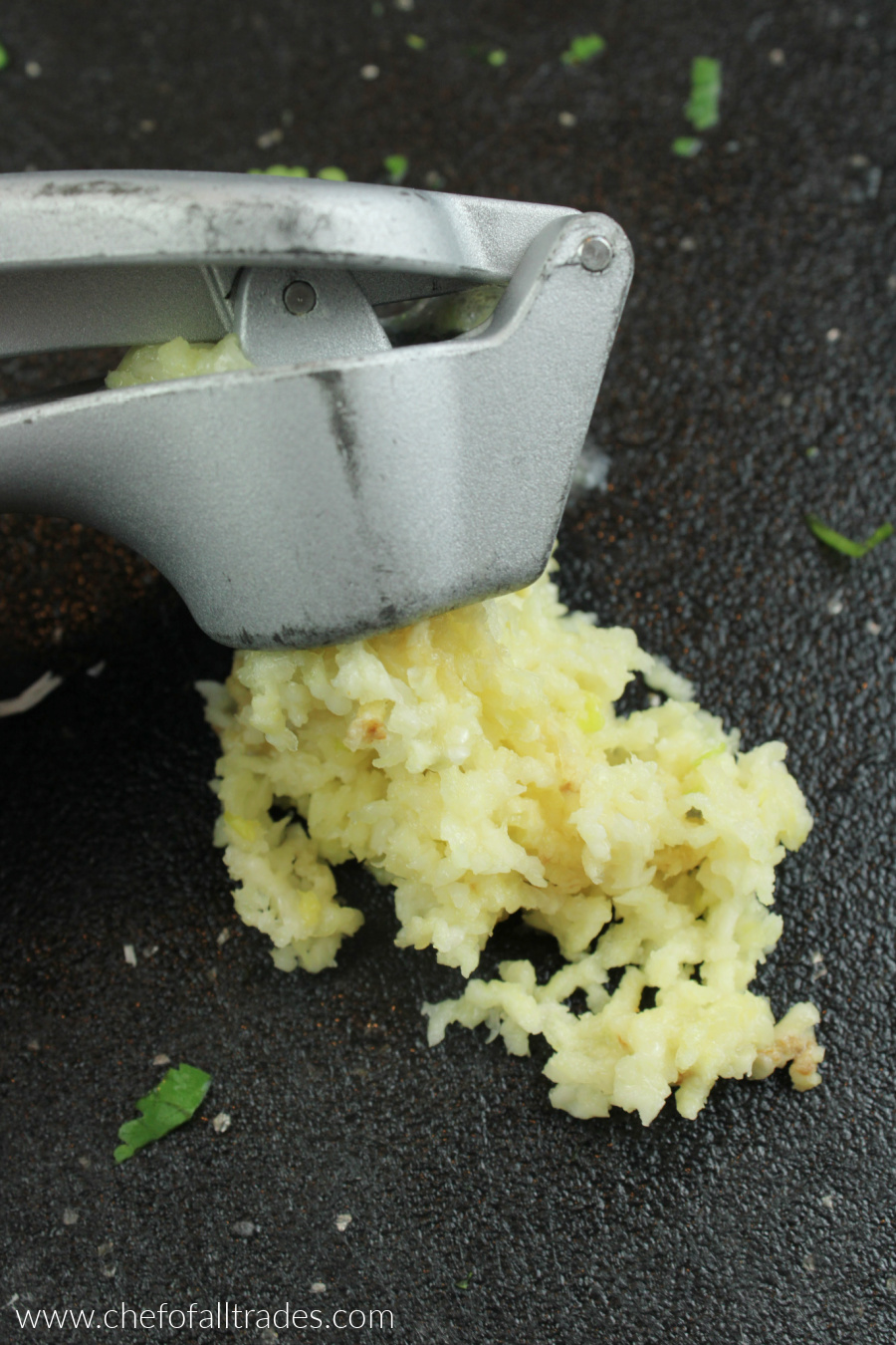 pressed garlic on a black cutting board